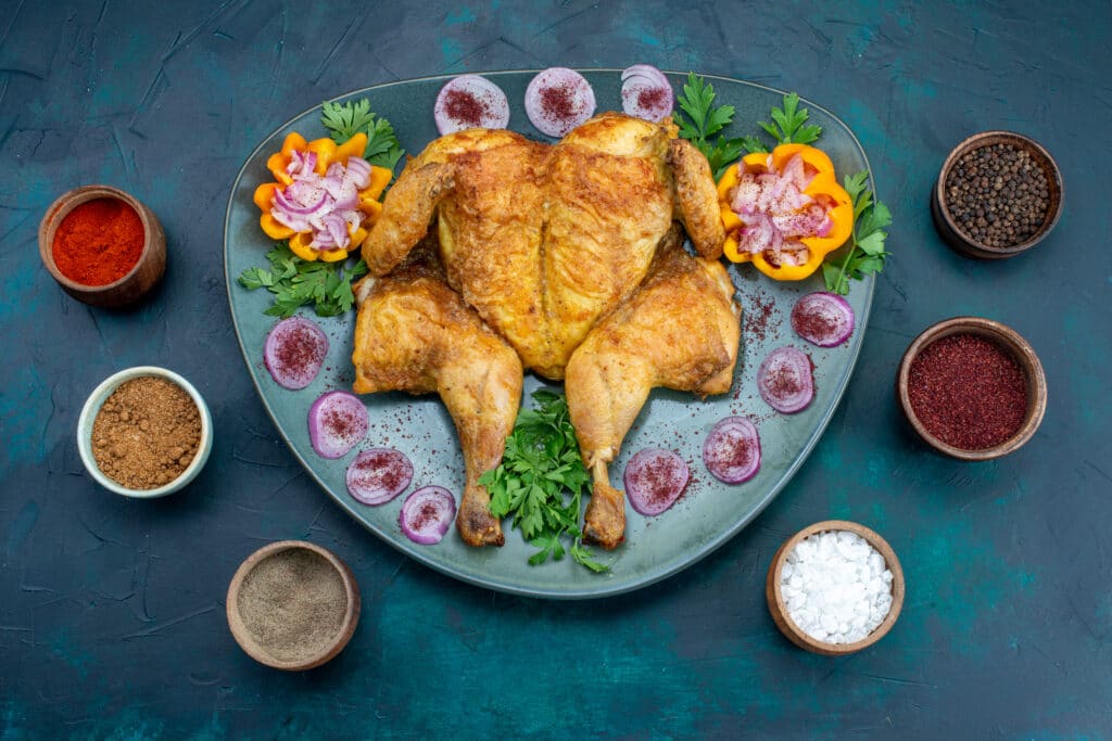 top view cooked chiken with onions greens inside plate dark blue desk chicken meat bake oven dinner